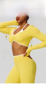 Détail des coutures contrastées et plissé poitrine sur ce haut de yoga jaune à manches