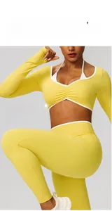 Détail du haut de yoga jaune à manches longues et du legging taille haute en tissu extensible