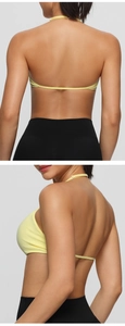 Detail view of the light yellow halter sports bra with thin straps and open back design