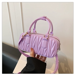 Close-up of purple mini tote bag featuring vertical quilted texture and gold hardware
