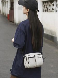Cream canvas crossbody bag with multi-pocket design for outdoor travel and leisure