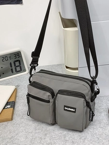 Grey multi-pocket canvas crossbody bag with adjustable strap for outdoor travel