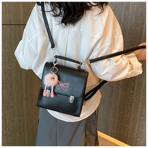 Détail du sac noir multi-usage avec broderie papillon rose et breloque en peluche