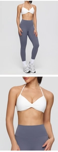 Close-up detail of white halter sports bra with center pleats and seamless gym fabric