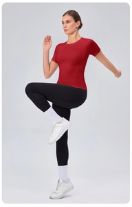 Dynamic pose of a red tight-fit short sleeve sports t-shirt with high waist yoga leggings