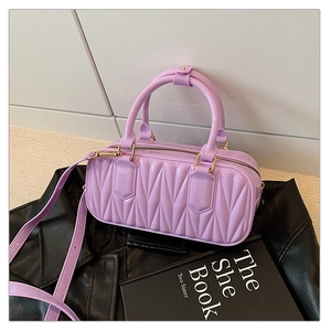 Detail of lavender quilted jelly bag with gold hardware on a black leather jacket