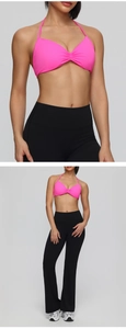 Detail of hot pink halter neck sports bra and black high-waisted flared yoga pants set