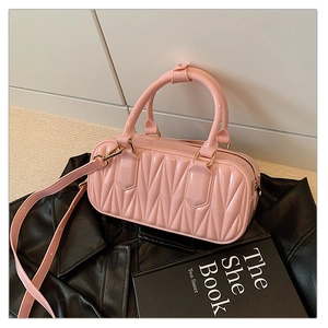 Detail of pink quilted leather mini bag with gold hardware on a leather background