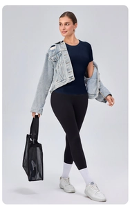 Detail of tight fit navy blue yoga t-shirt paired with leggings and a denim jacket