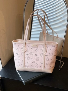 Rosa Tragetasche mit Cartoon-Bären-Prints und langen Schultergurten auf einem Buch