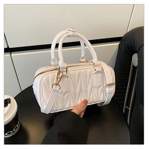 Detail of white geometric quilted mini Boston bag with gold-tone hardware and straps