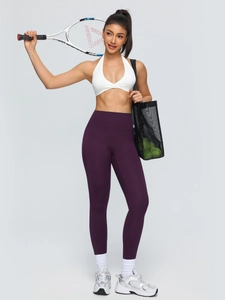 Women's white halter sports bra and high waisted purple yoga leggings set for fitness