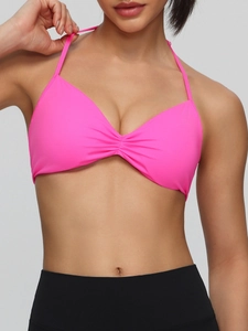 Neon pink halter neck sports bra with ruched chest detail for yoga and fitness
