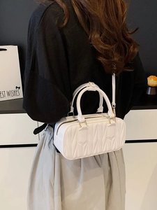 White quilted matelassé crossbody bag with top handles and elegant gold hardware