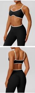 Detail of black yoga set with white contrast piping and ruched sports bra design