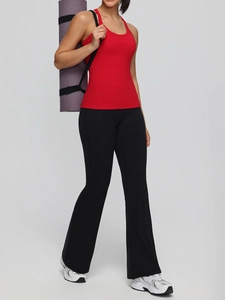 Women's red racerback sports tank top with built-in pads and black high-waisted flared yoga pants