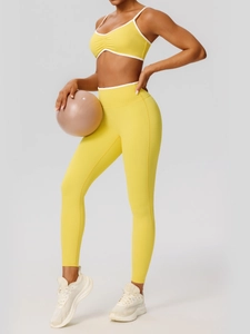 Two-piece vibrant yellow yoga set with strappy sports bra and high-waisted leggings