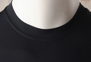 Detail of crew neck stitching and breathable fabric on men's black compression gym shirt
