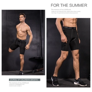 Close-up of men's compression shorts with elastic logo waistband in a gym setting