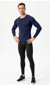 Full-body view of men's navy compression top and black leggings for gym training