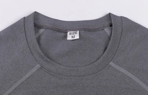 Close-up of the round neckline and stitching on a dark grey men's compression sports shirt