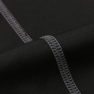 Close-up of durable gray flatlock stitching on black quick-dry compression fabric pants