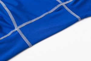 Close-up of flatlock stitching on blue quick-dry compression shorts for durability