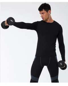 Men's compression long sleeve top and leggings set shown with dumbbells during workout