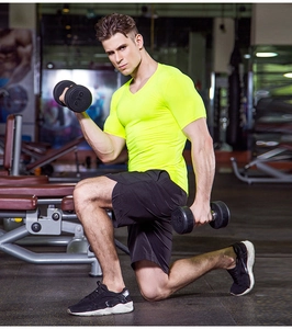 Detail view of neon yellow compression t-shirt and black gym shorts for pro fitness