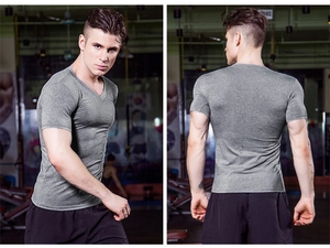 Men's V-neck compression shirt in grey high-elastic fabric showing muscle fit in gym