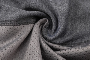 Détail du tissu en maille gris foncé respirant et des coutures extensibles de sport