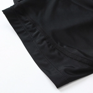 Detail of flatlock stitching on black moisture-wicking athletic shorts fabric