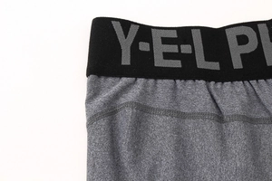 Détail du short de sport gris avec ceinture élastique et lettrage Y-E-L P sur la taille