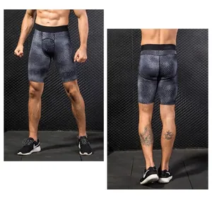 Detailed view of men's grey compression shorts with 3D geometric scale pattern and elastic waist