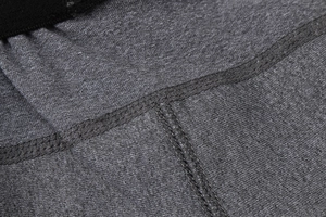 Vue détaillée des coutures plates et du tissu en maille gris chiné du short de sport homme