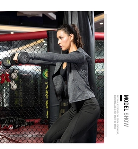 Detail of gray hooded zipper sports jacket with black yoga bra in a gym setting