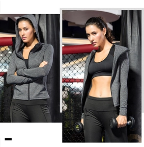 Detail view of women's grey fleece zip hoodie and sports leggings in gym setting