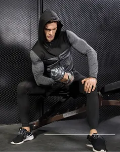 Detailed close-up of hooded men's sports jacket featuring grey-black patchwork design