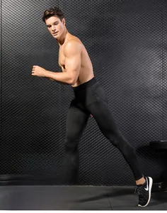 Detail of men's black compression pants showing stretch fabric in a fitness setting