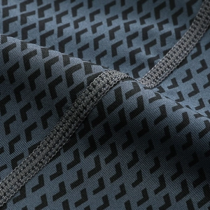 Macro view of blue 3D geometric print fabric with durable flatlock reinforced stitching