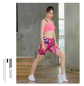 Detail view of pink sports bra and camo yoga shorts on model for fitness workouts
