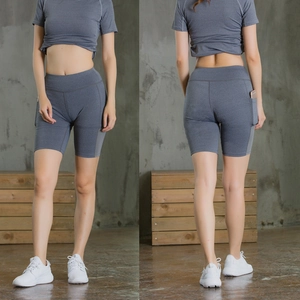 Detail showing high-waisted gray yoga shorts with side pocket for phone storage