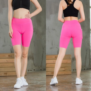 Detail view of pink high-waist yoga shorts with side pockets and elastic fabric