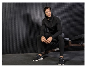 Detail of men's quick-dry hooded sports jacket and compression pants for gym workouts