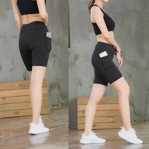 Detail view of high-waisted black yoga shorts with functional side pockets for phone storage