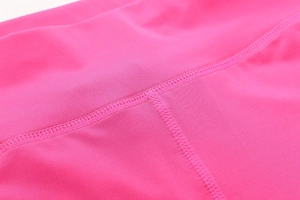 Macro shot of magenta yoga shorts showing premium four-needle six-thread flatlock seams