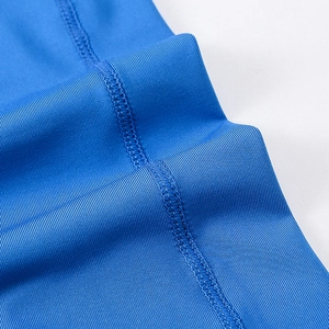 Close-up of blue compression pants showing elastic fabric with professional flatlock seams