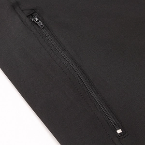 Macro view of a black athletic jacket showing a secure zippered pocket and fine knit texture