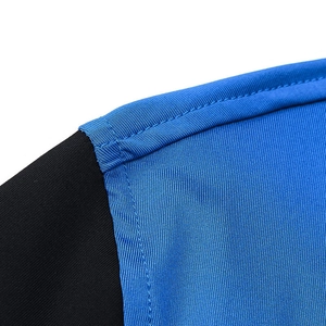 Macro shot of reinforced seams on blue and black moisture-wicking men's sports hoodie