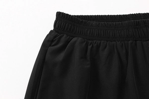 Detailed close-up of the elastic waistband with vertical pleats on men's black sports leggings